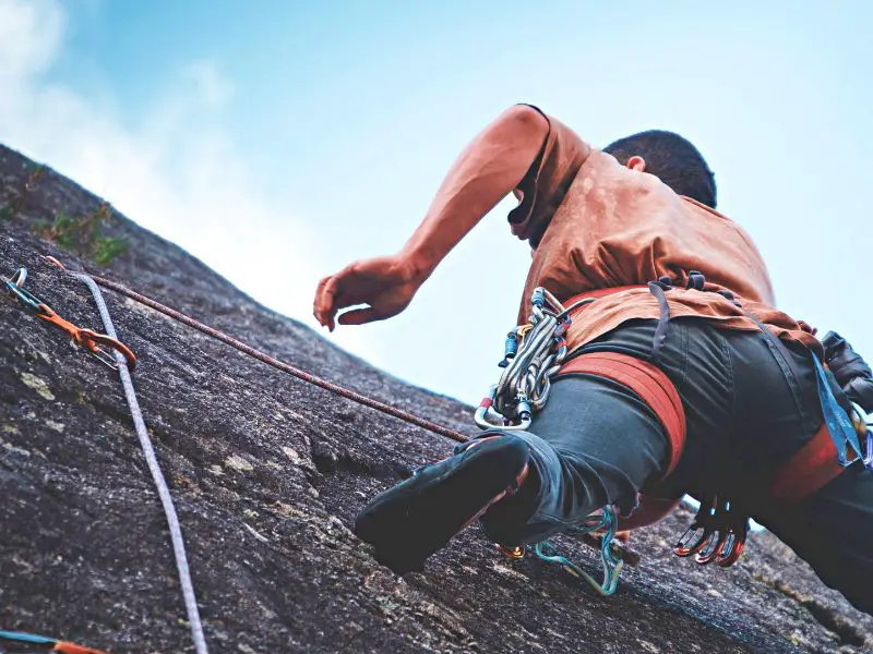 Man with harness climbing in Acadia National Park