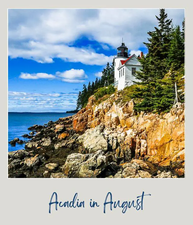 View of the white lighthouse on the rock mountains surrounded by trees and ocean in Acadia National Park.