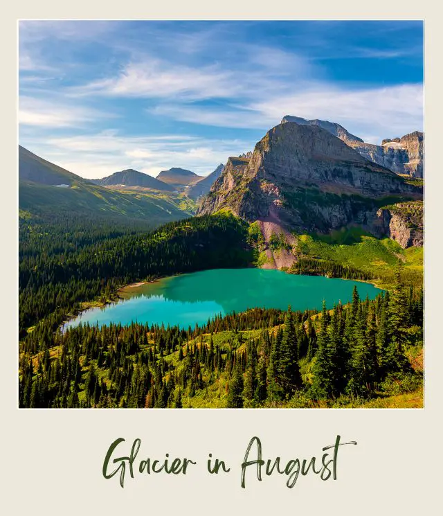 A blue lake surrounded by trees and huge mountains in Glacier National Park.