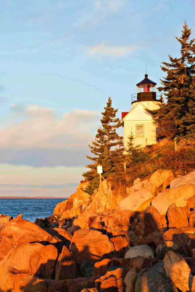 glowing rocks at sunrise and Bass Harbor Head Lighthouse in Acadia National Park