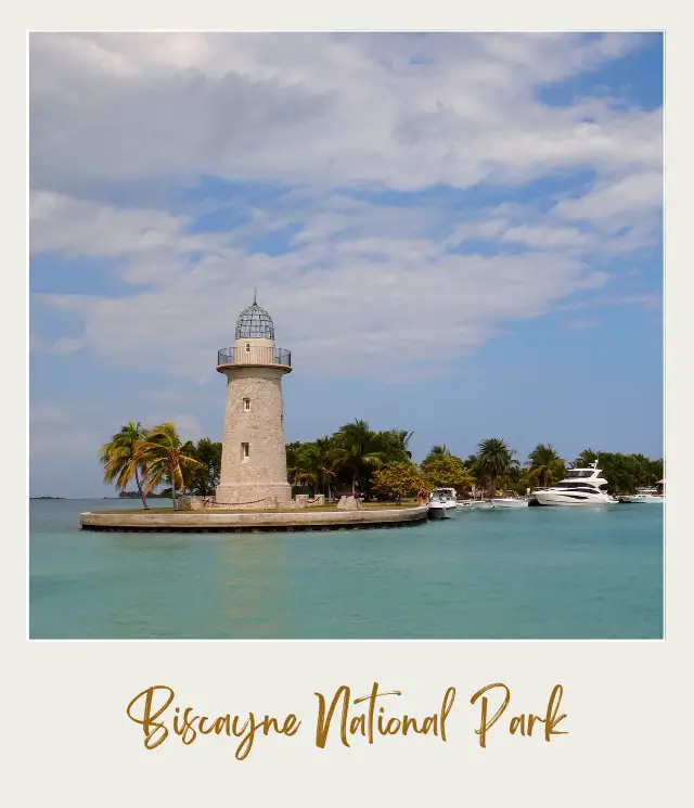 View of the lighthouse surrounded by palm trees and beside are yachts in Biscayne National Park.