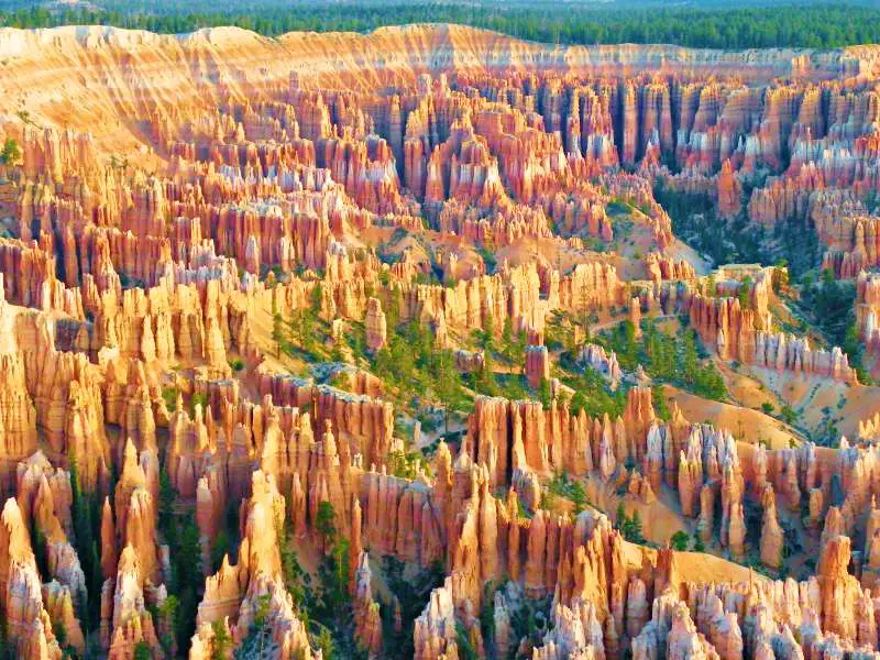 Aerial view of a huge red rock formation surrounded by trees in Bryce Canyon National Park