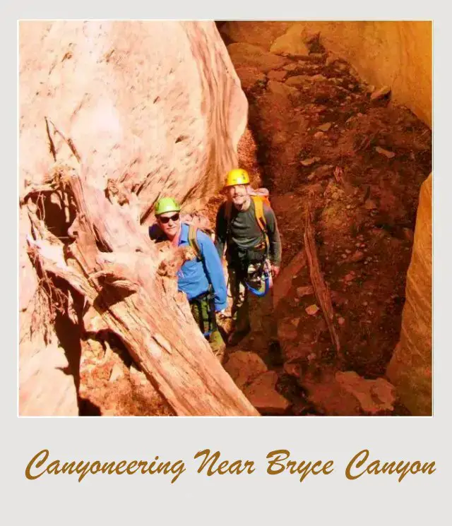 two men standing in narrow slot canyon seen from above