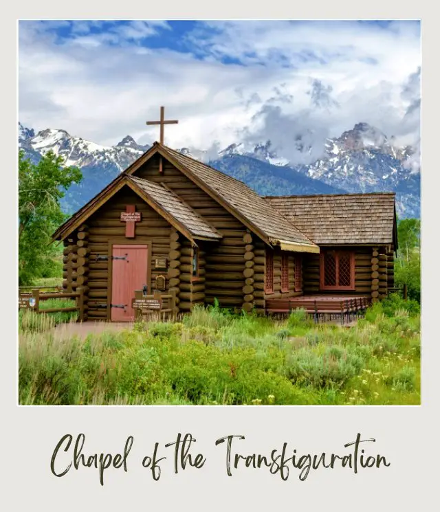 The wooden chapel of the Transfiguration is surrounded by trees, grasses, and mountains in Grand Teton National Park.