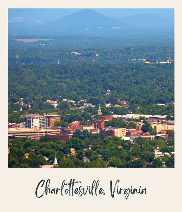 Aerial view of Charlottesville with town surrounded by woods and hills
