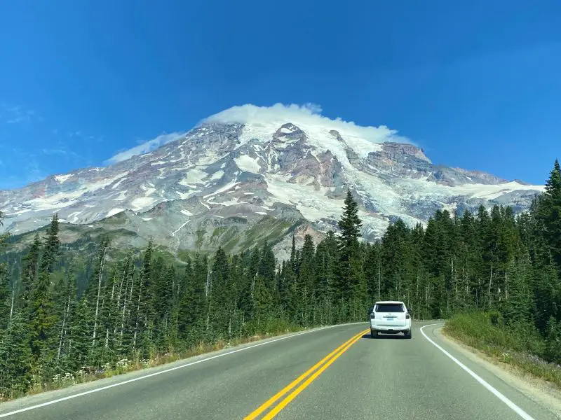 car on road with Mount Rainier in background