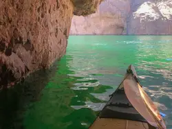 front of kayak with green water and cave overhang
