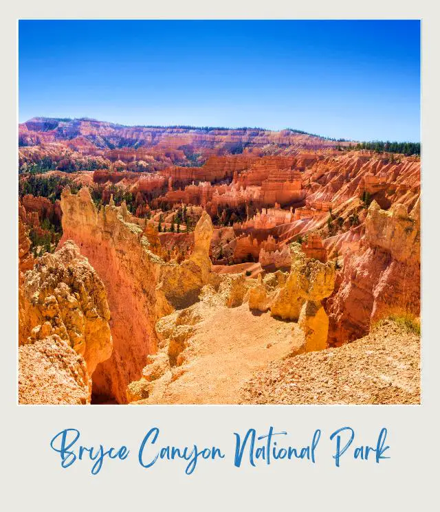 View of hoodoos surrounded by trees under the blue sky in Bryce Canyon National Park.