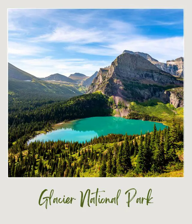 A blue lake surrounded by trees and huge mountains in Glacier National Park.