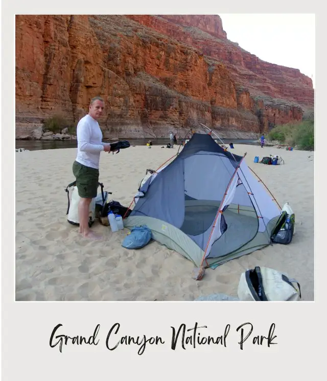 man standing next to tent on beach inside grand canyon on river rafting trip through grand canyon