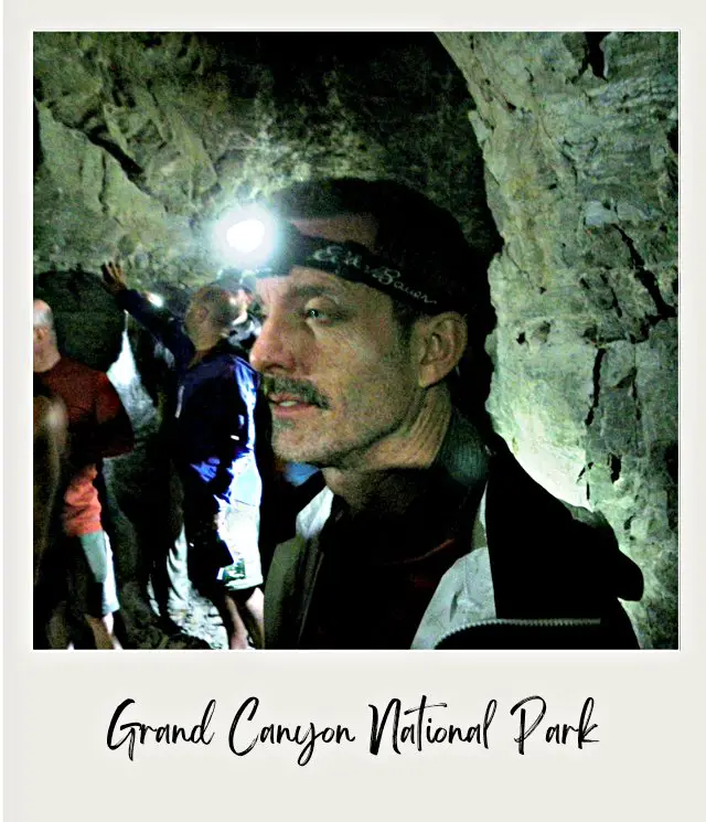 man in mine with headlamp inside abandoned tunnel in grand canyon on river trip through grand canyon