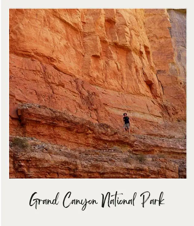 man standing on side of cliff on river rafting trip through grand canyon