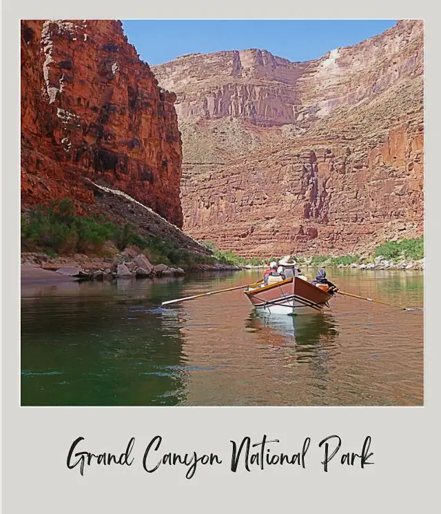 small wooden boat surrounded by large canyon on river rafting trip through grand canyon