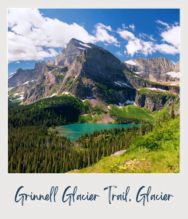 View of a blue lake surrounded by trees and mountains in Grinnell Glacier Trail, Glacier National Park.