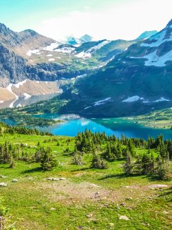 Glacier National Park 3 Day Itinerary filed with lake surrounded by peaks with some snow