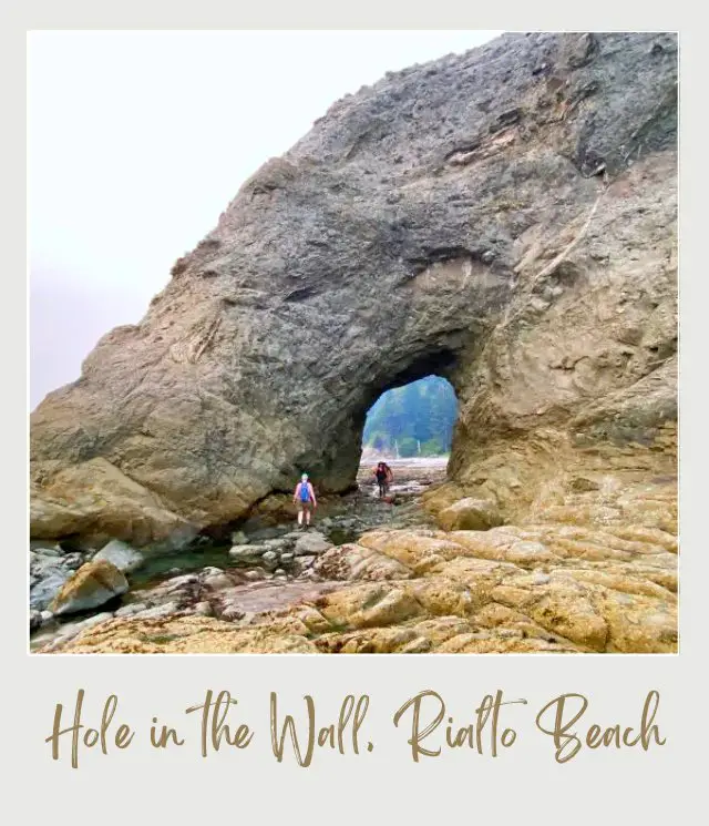 Rialto Beach - Hole in the Wall, Olympic National Park: Complete Guide Two people in the hole of the huge rock formations in Rialto Beach, Olympic National Park.
