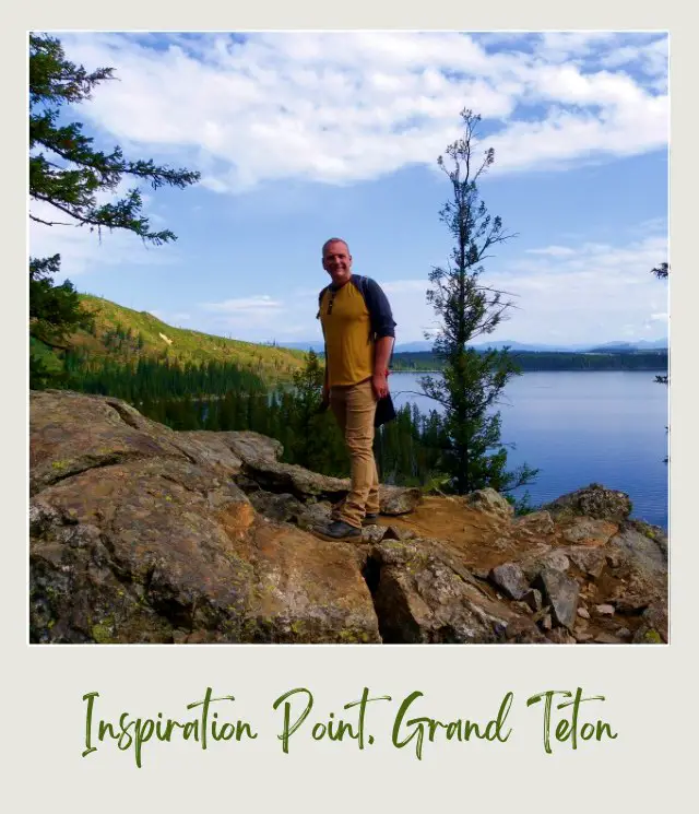 James standing on the rock mountain and behind is a lake in Grand Teton National Park.