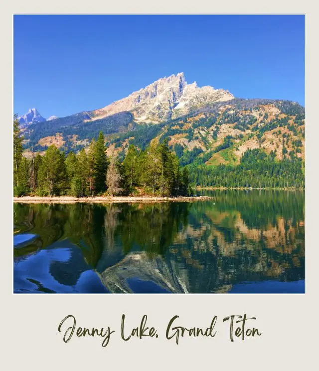 View of lake with the reflection of mountains and behind are trees and mountains in Cascade Canyon in Grand Teton National Park.