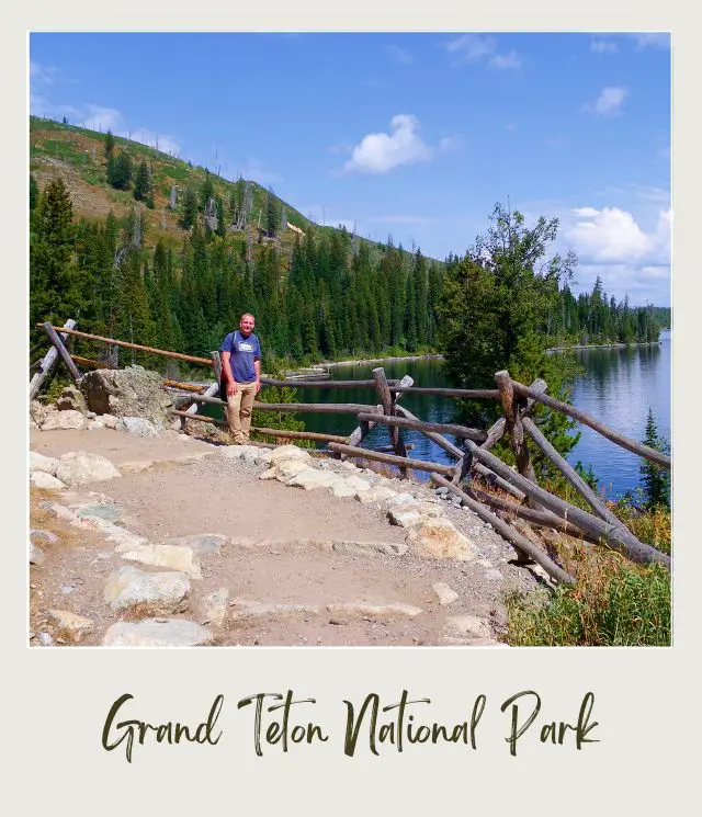 James standing on the end of the Cascade Camnyon trail, and behind is a huge lake, trees and mountains in Grand Teton National Park.