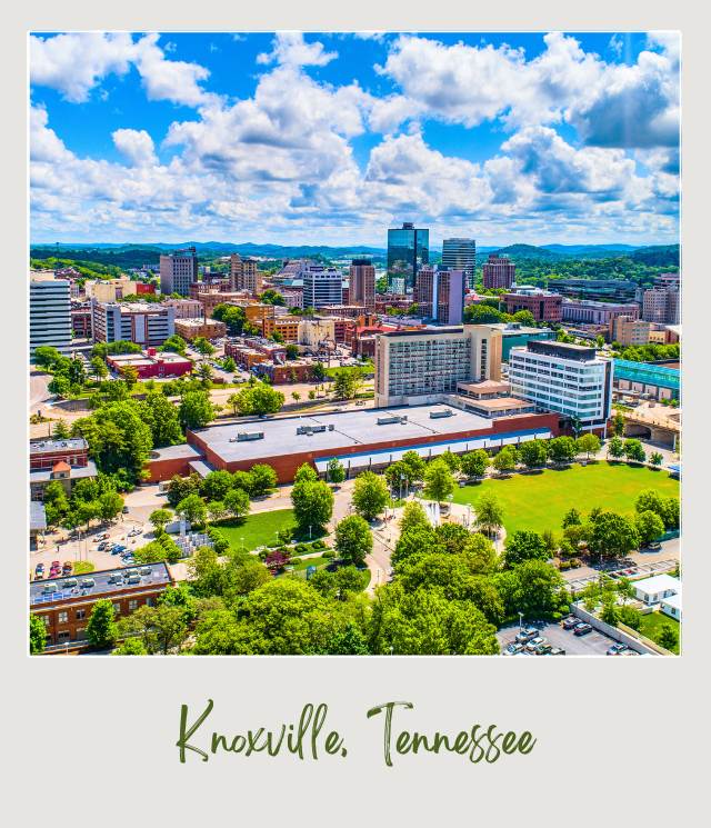 Buildings surrounded by trees under clear blue sky and behind are mountains in Knoxville Tennessee near McGhee-Tyson Airport