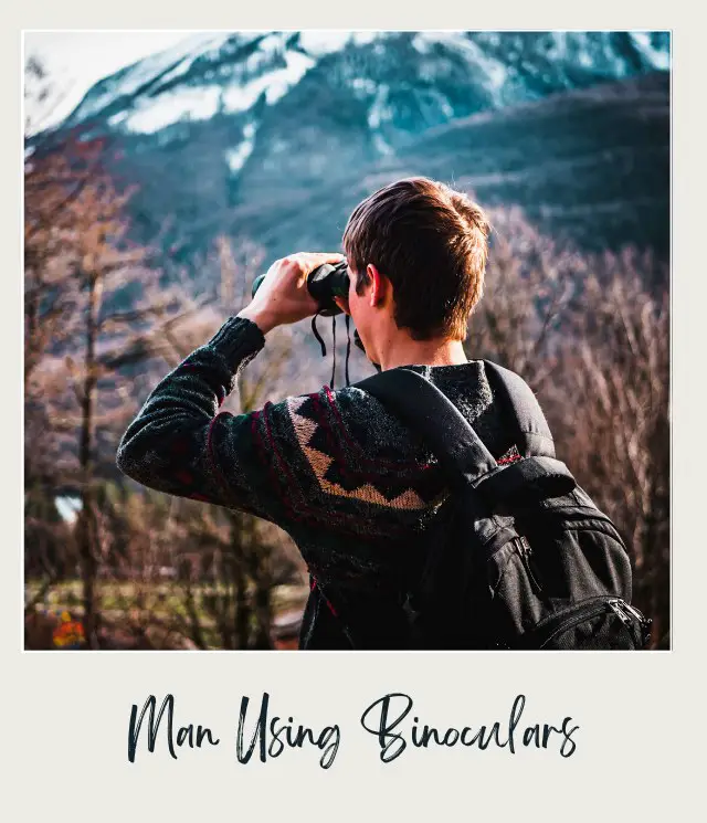 Man Using Black Binoculars Near Forest Trees at Daytime