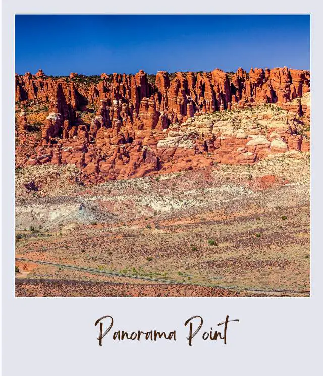 View of huge rock formations and bushes in Arches National Park.