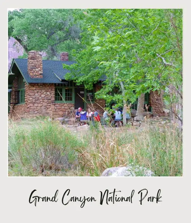 People gather beside the house surrounded by trees in Phantom Ranch Grand Canyon National Park.