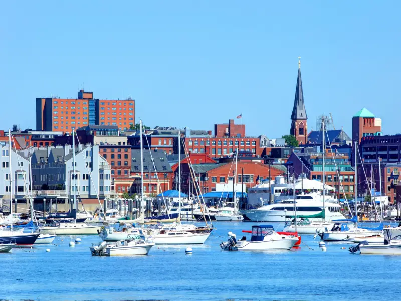 harbor with lots of small boats and warehouse type buildings plus a church steeple in portland maine