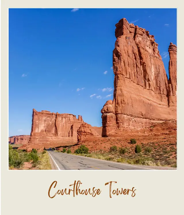 View of huge rock formations, concrete highway at Courthouse Towers in Arches National Park.