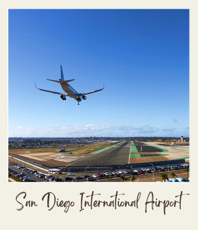 A Plane is going to land at the rectangular runway at San Diego International Airport, and outside are cars parked near the airport in San Diego.