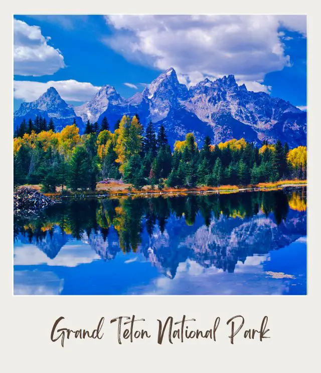 Lake surrounded by trees and behind is a snow-capped mountain under a cloudy and blue sky