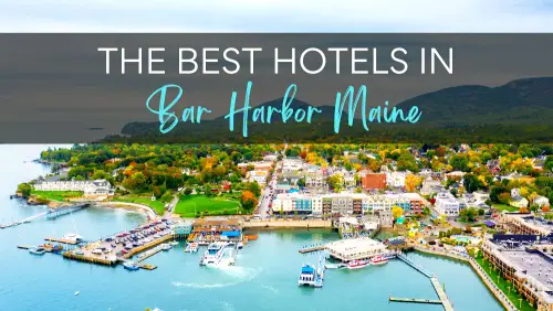 Aerial view of Bar Harbor waterfront with boats, hills, and vibrant trees and buildings, with the text, "The Best Hotels in Bar Harbor Maine."