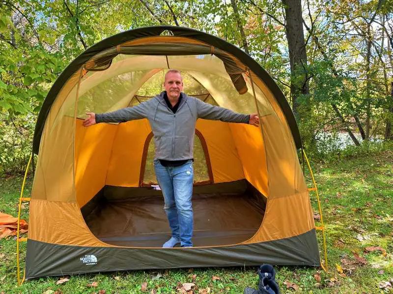 man standing up inside The North face wawaona 4 tent to show size