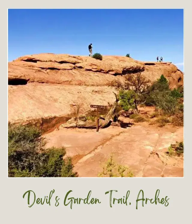 People walking above the huge rock formations in Devils Garden in Arches National Park.