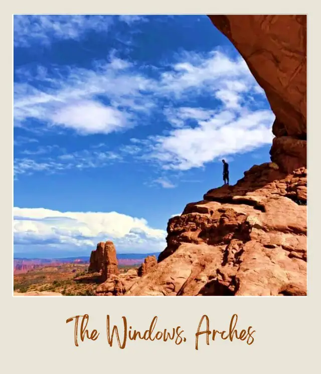 View of a person standing on the rock mountain in Arches National Park.