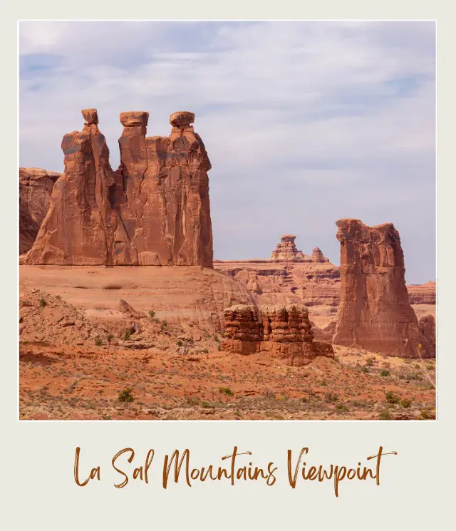 Huge rock formations and bushes in Arches National Drive.