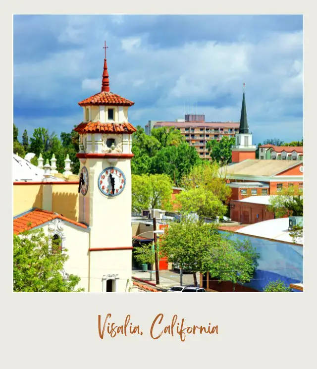 A clock tower in the middle of the city, surrounded by buildings and trees in the daytime in Visalia, California, near Visalia Municipal Airport