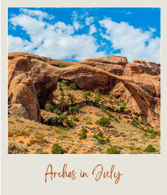 View of rock formations surrounded by bushes under the blue skies in Arches National Park.