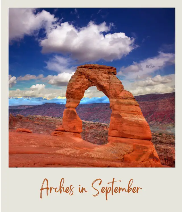 A huge rock arch and behind are rock mountains under the blue sky in Arches National Park