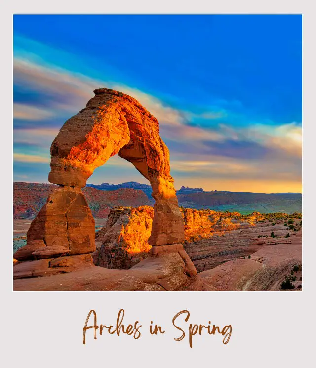 Rock spire forming arcs surrounded by red stone cliffs in the middle of a sunny day