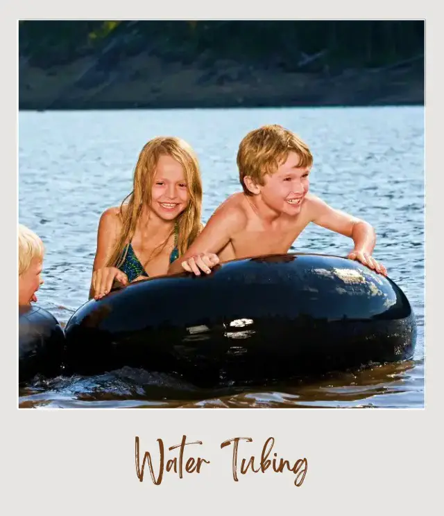 Three kids riding in water inflatable tubing in the middle of the water in Zion National Park