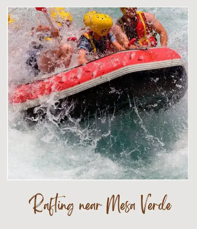 A red and black inflatable raft bounces through white water rapids, carrying several people wearing life vests and helmets in Mesa Verde National Park