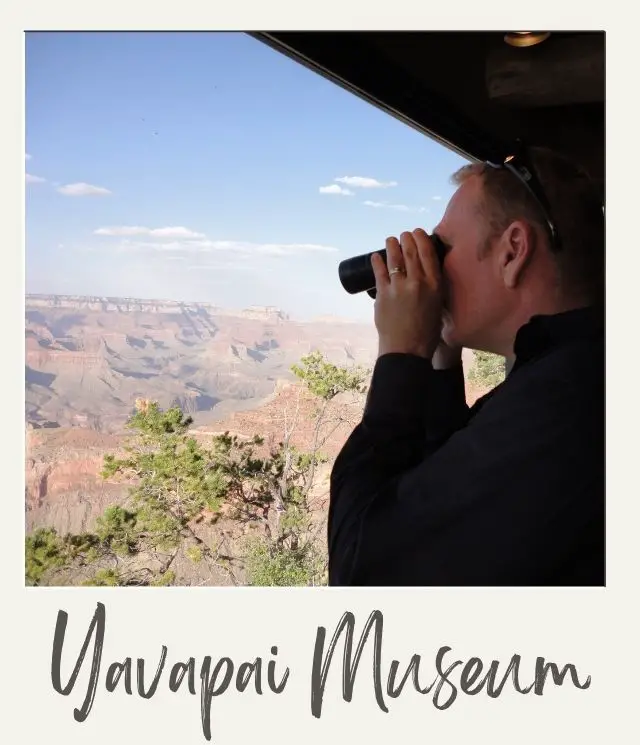15 Best Things to Do in Grand Canyon for Non Hikers: Views Without the Sweat man (James Ian) looking through binoculars with a roof above so it is inside lookign at the Grand Canyon