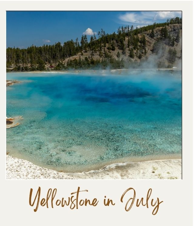 Yellowstone National Park in July: What To Expect blue pool with steam and wooded hill behind in Yellowstone in July