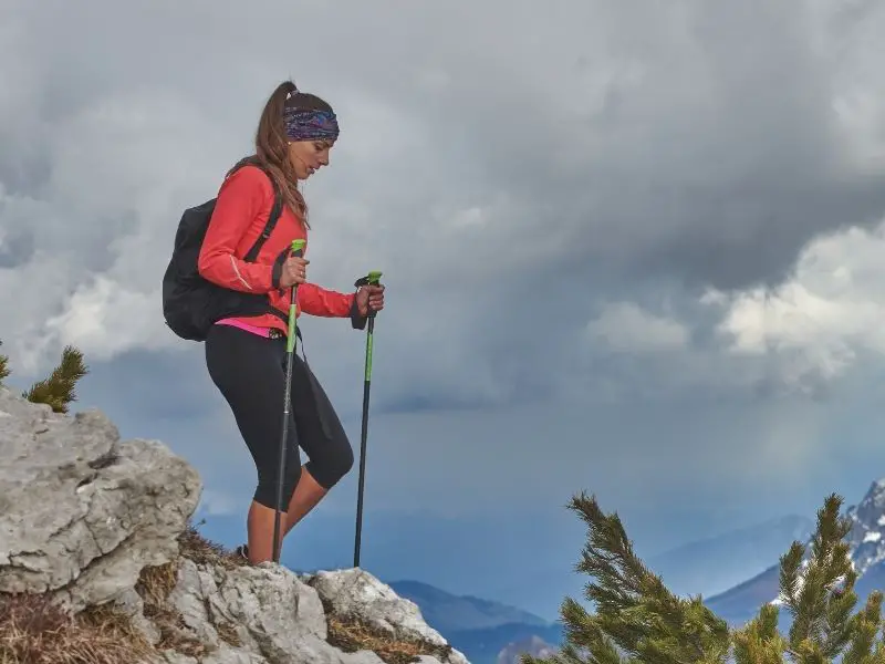 How to Use Trekking Poles: A Complete Guide for Hikers (With Pro Tips) woman hiking downhill with hiking poles