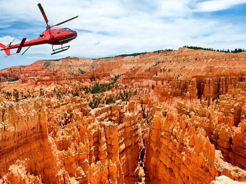 A red helicopter above the red cliffs in Bryce canyon